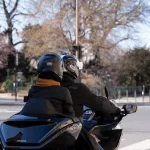 Moto taxi circulant sur Paris. deux passagers et en arrière plan la tour Eiffel
