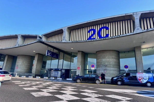 des vehicules sous un blog de béton de forme oval. Ecrit dessus 2C