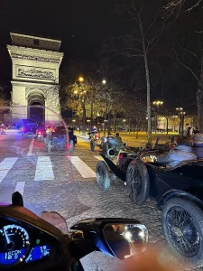 Moto taxi ACTIFcab escortant une Bugatti devant l'Arc de Triomphe à Paris
