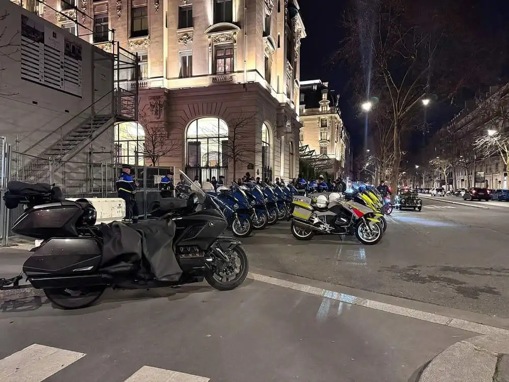 plusieurs moto stationné de police. Ils sont devant un batiment de nuit