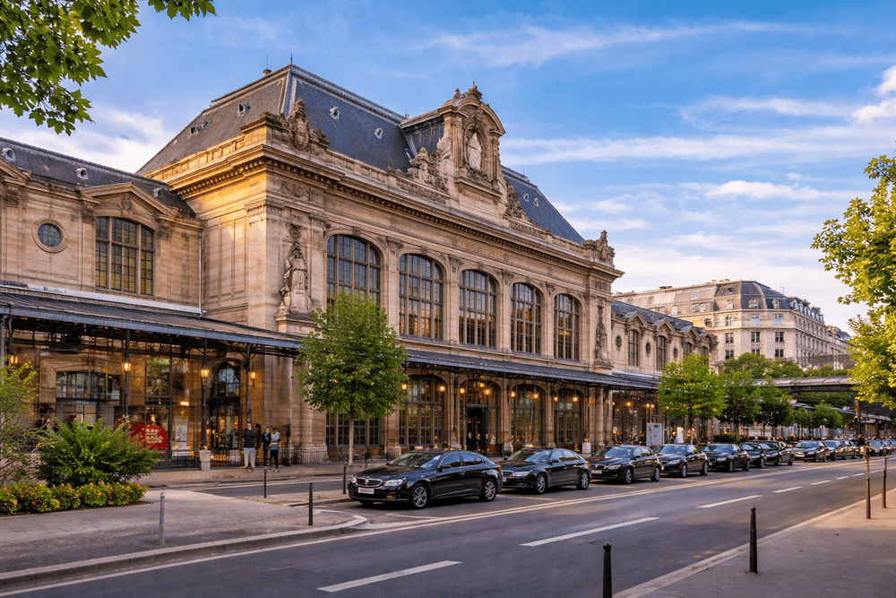 des véhicules garées devant une gare. Coucher de soleil temps chaud