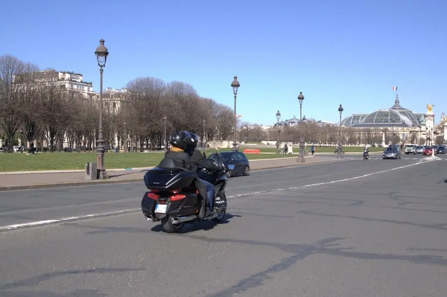 Moto taxi Paris circulant devant le Grand Palais, service de transport rapide disponible 7j/7