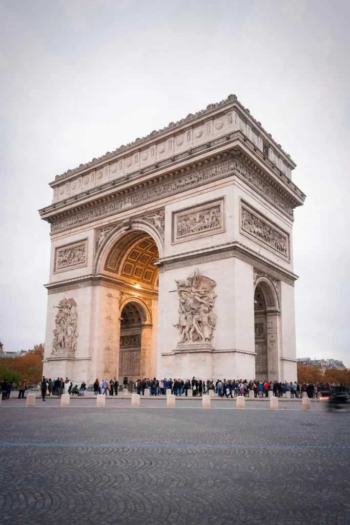 arc de triomphe sous un coucher de soleil. Des personnes son tout au tour du monument